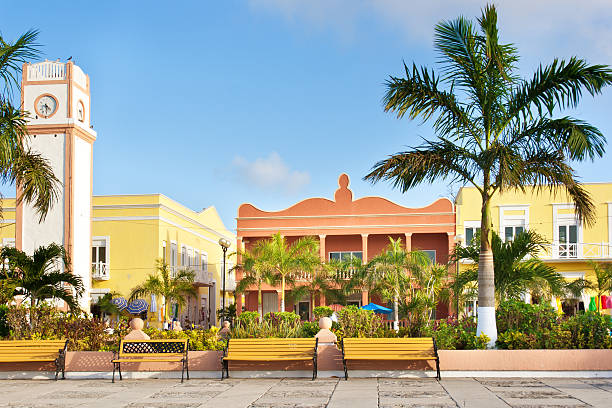 The clock Tower and town square, the Plaza del Sol, San Miguel of Cozumel, Mexico. Cozumel, a tropical island off the coast of Cancun, Mexico, in the Riviera Maya. A popular tourist destination, the central Plaza, a tourist shopping area, lined with entertainment, restaurants, and retail shops tailored to the tourists.
